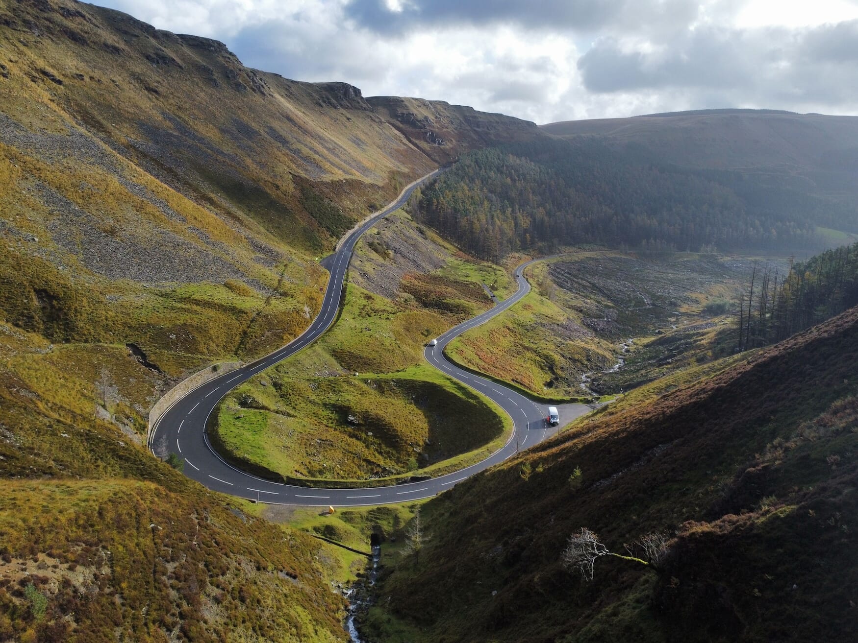 A top view of curvy Bwlch-y-Clawdd Road surrounded by valley on a sunny day, Treorchy, Wales